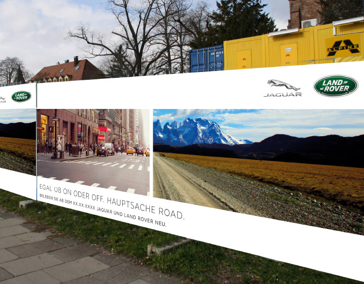 An image of a fence surrounding a construction site. 
                The fence is covered with a sign showing a split view of a city street and a dirt road with mountains in the background. 
                The headline reads Egal Ob On Oder Off. Hauptsache Road.